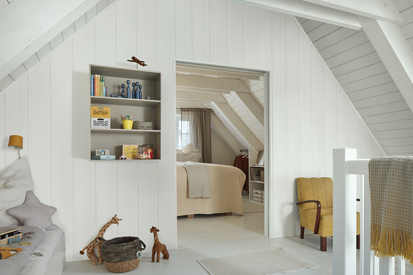 Weiße Wandverkleidung mit sichtbarer Holzstruktur in modernem Kinderzimmer im Dachgeschoss.