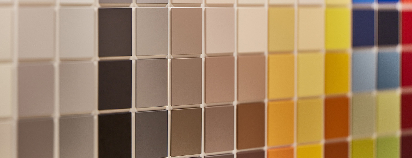 Farbauswahl an HPL-Schichtstoffplatten in verschiedenen Nuancen von Beige, Braun, Grau bis hin zu leuchtenden Farben wie Gelb, Rot und Blau für den Möbel- und Innenausbau.
