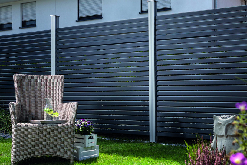 Moderner Alu-Rhombus-Sichtschutzzaun in Anthrazit mit stilvollem Gartenambiente und Loungesessel.