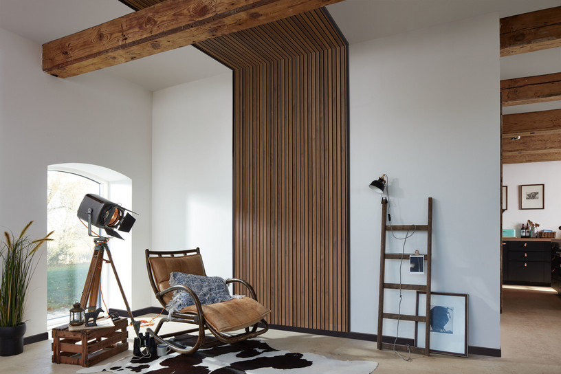 Vertikale Akustikpaneele in Holzoptik als Wand- und Deckenlösung im Wohnraum.