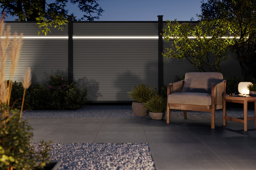 Moderner Sichtschutzzaun aus Aluminium mit horizontaler LED-Lichtleiste in stimmungsvoll beleuchtetem Garten.