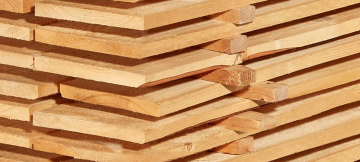 Gestapelte Schalbretter aus Holz mit sägerauer Oberfläche, ideal für den Bau- und Konstruktionsbereich.